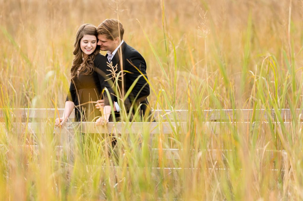 Engagement couple on a small bridge in a field
