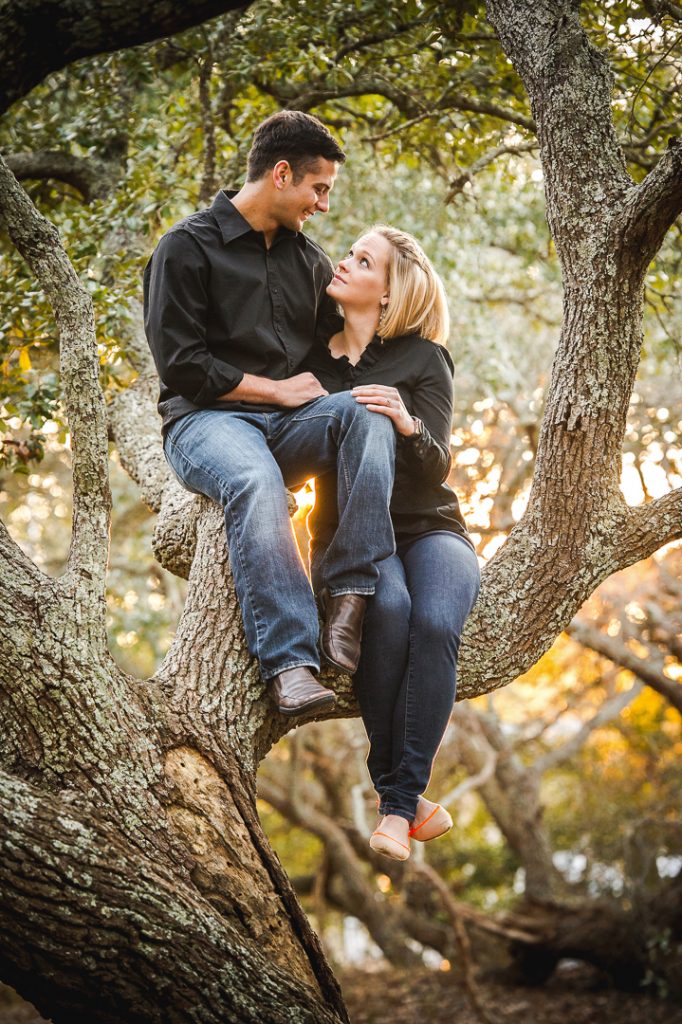 Engagement session couple sitting in a tree at First Landing State Park
