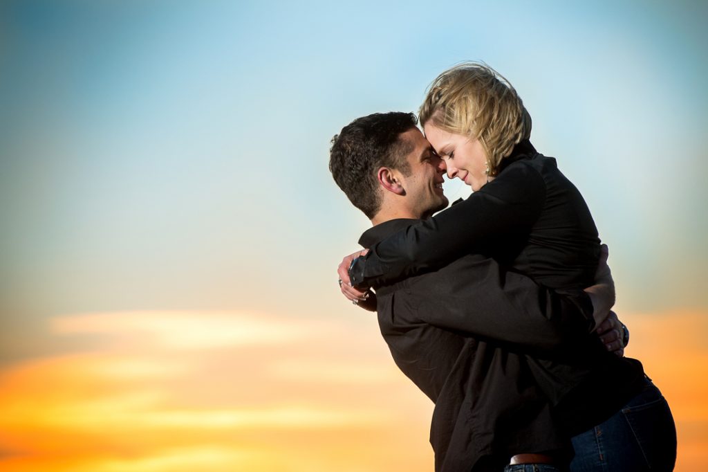 Engagement session couple touching foreheads at sunset in Virginia Beach