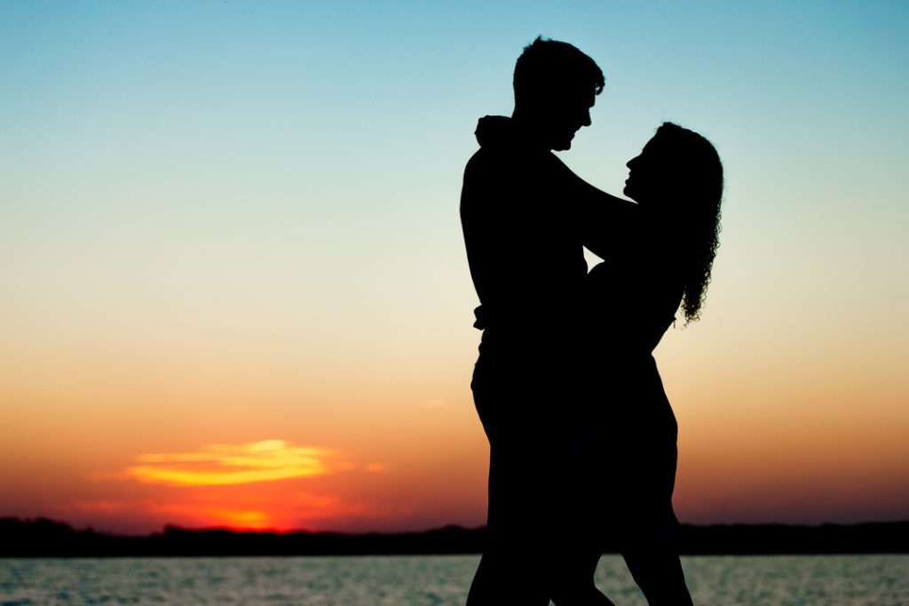 Sunset silhouette of engaged couple at Back Bay