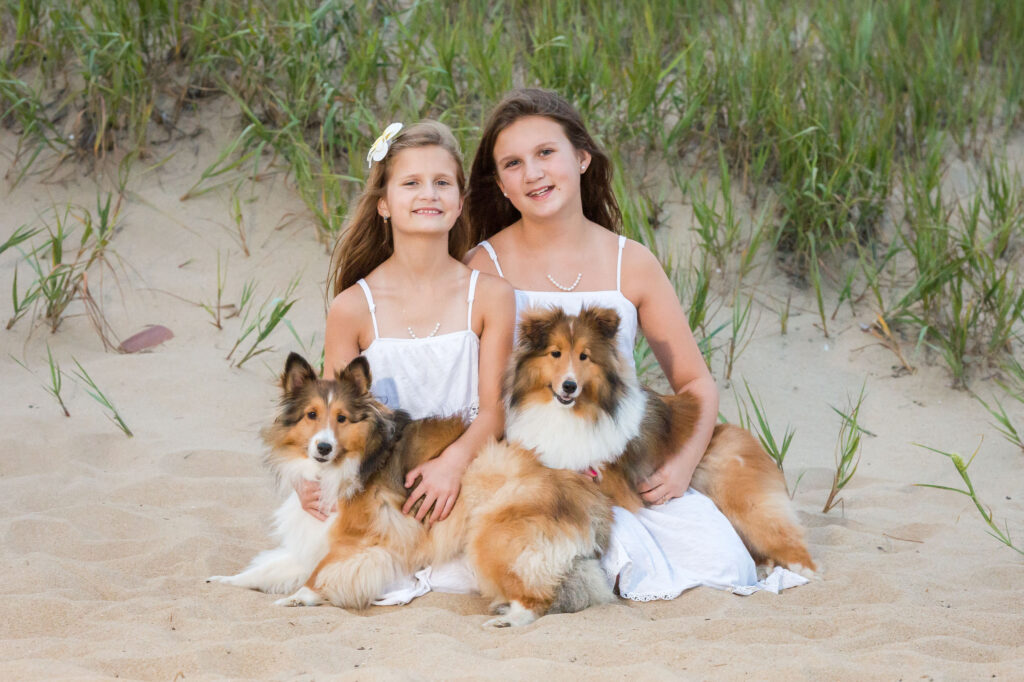 Family portrait of two sisters with the family dogs