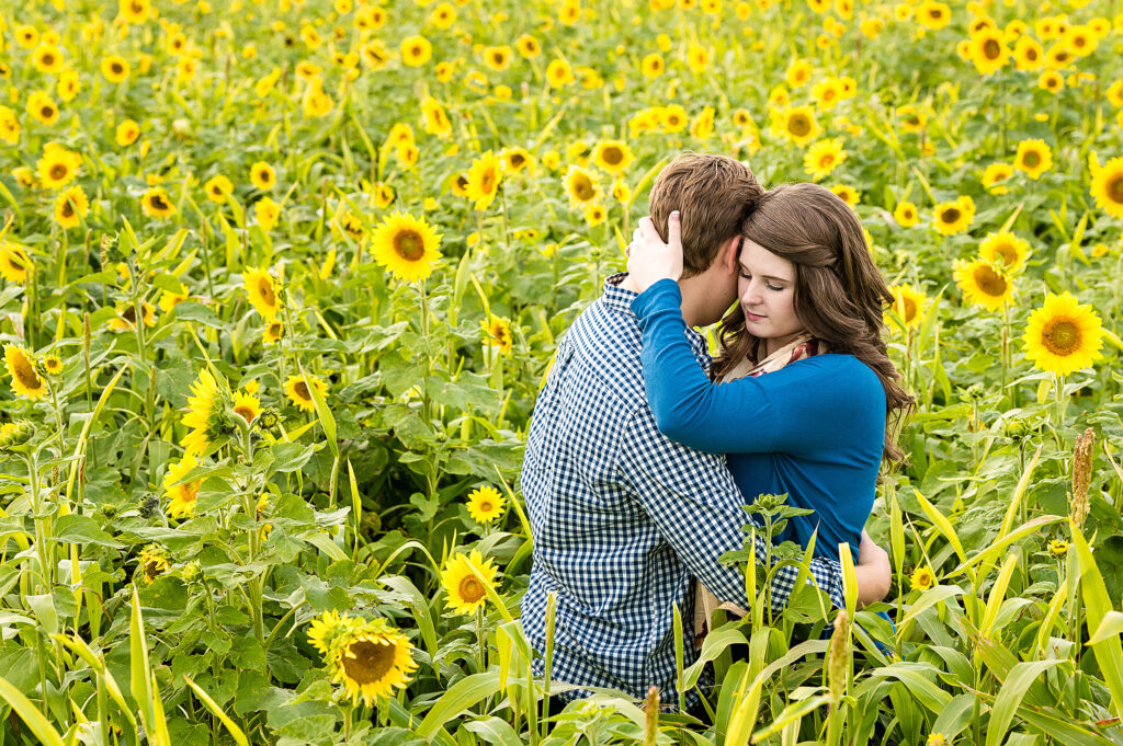 young couple embracing in field of sunflowers