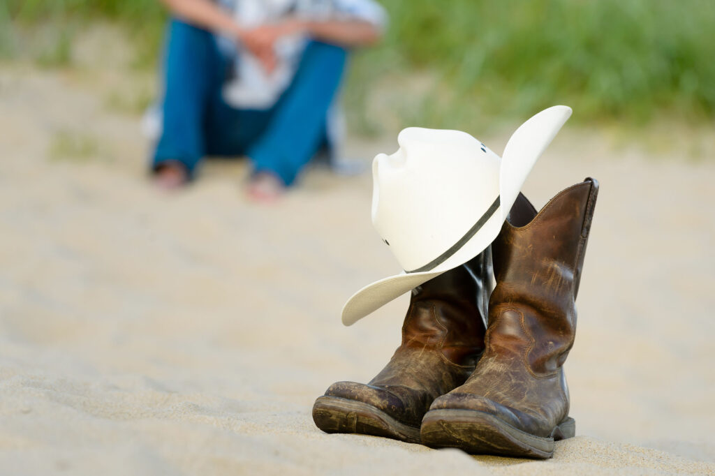 Senior portrait session of a young man's cowboy hat and boots
