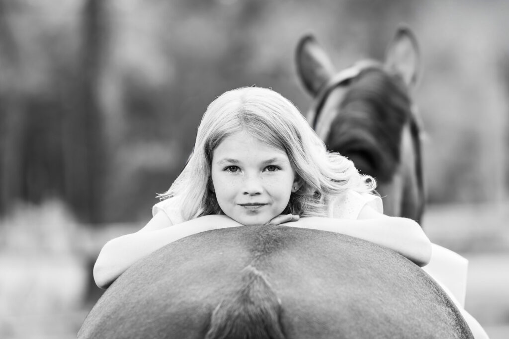 Black and white photo of little girl on the back of her horse in Chesapeake, VA