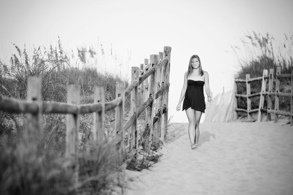 Black and white photo of a girl walking down the beach path in Sandbridge