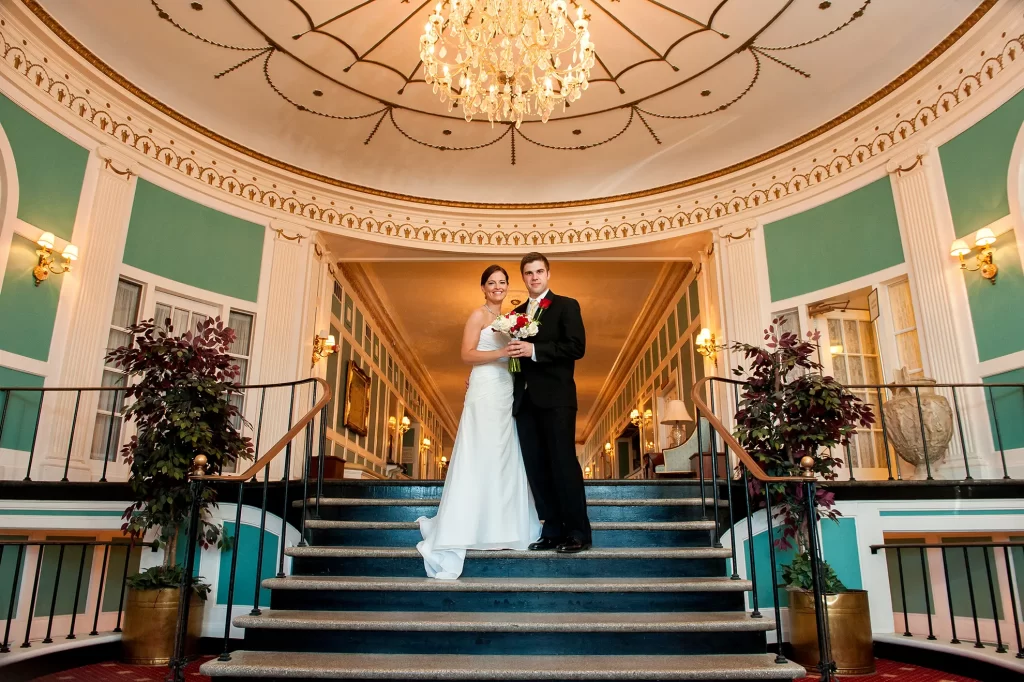Bride and Groom at the top of the steps in the foyer of the Cavalier Hotel