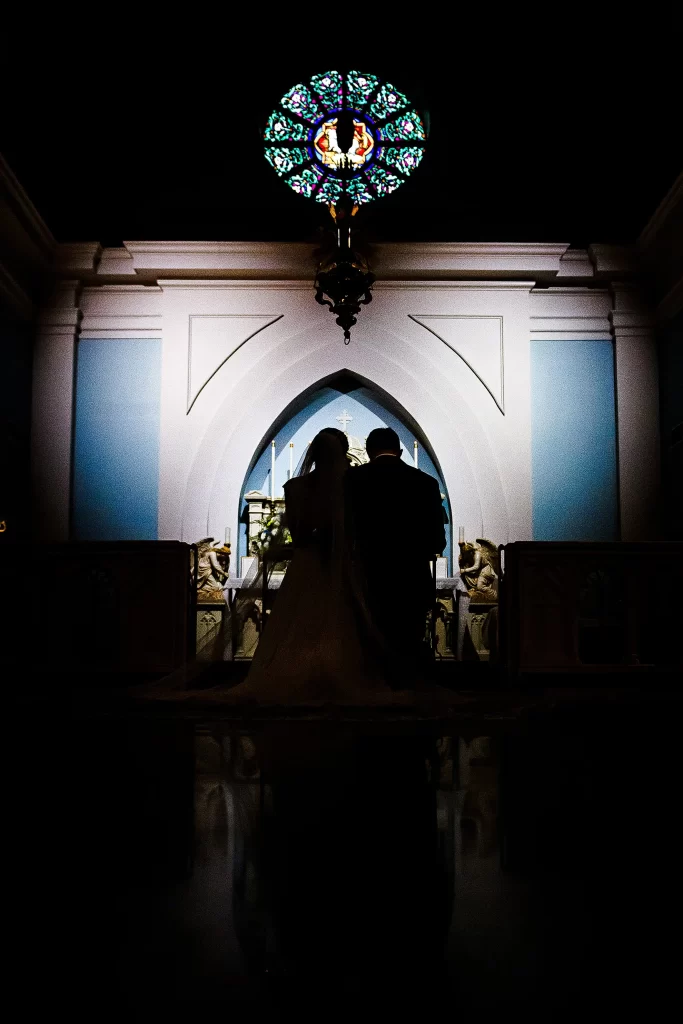 Bride and Groom at the alter with abstract lighting shaped as a heart